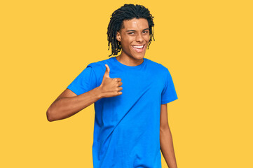 Young african american man wearing casual clothes doing happy thumbs up gesture with hand. approving expression looking at the camera showing success.