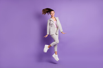 Full length photo of young woman happy positive smile have fun jump up wear suit isolated over violet color background