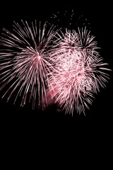 Luxury fireworks event sky show with red big bang stars. Premium entertainment magic star firework at e.g. New Years Eve or Independence Day party celebration. Black dark night background