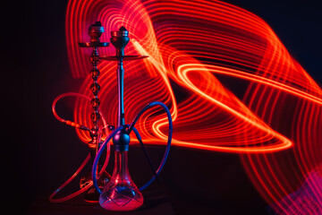 hookahs with shisha charcoal with red neon lighting on the table