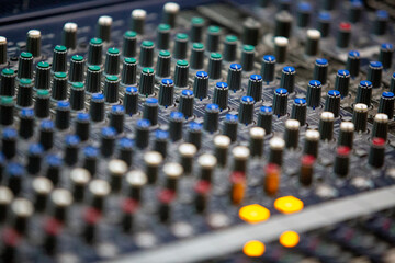 Professional sound deck with multiple knobs of different colors and settings, in close-up shot with...