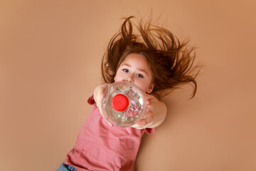 Little girl lying on ground with a bottle of water