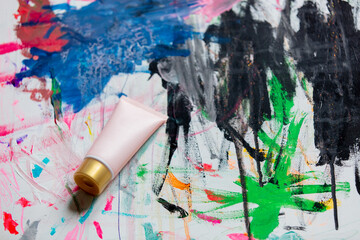Cream tube on a paint as background. Above view