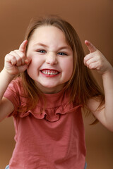 Portrait of smiling preschool girl with funny gesture