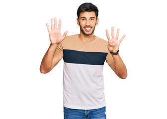 Young handsome man wearing casual clothes showing and pointing up with fingers number nine while...