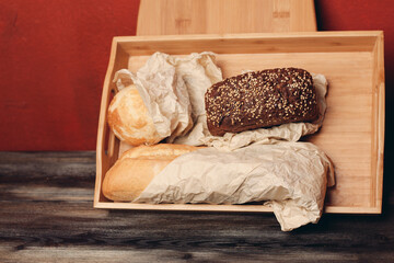 Fototapeta na wymiar flour products baked goods on a wooden tray and a board in the background on the table