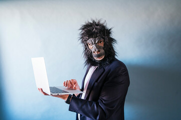 Man with gorilla mask using laptop © karrastock