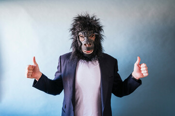 Man with gorilla mask looking at camera and showing thumb fingers