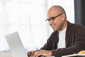 Indian man using laptop chatting with online social media. Work from home.