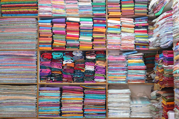 Indian fabrics. Oriental fabric store in India. Shelves with multi-colored woven materials.