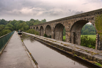 Narrowboat on the Chirk Aqueduct, Llangollen Canal, on the border between England and Wales during a shower of rain