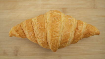 Close up Freshly baked croissants on wooden cutting board, top view. Crescent-shaped bread originated in France. The popular breakfast menu spread all over the world.