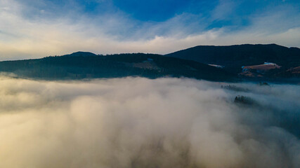 Obraz premium mountains tops high above clouds fog
