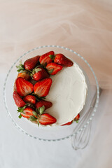 white cake with cream garnished with strawberries on a tray