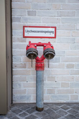 Fire water supply with two outlets is located at a building.