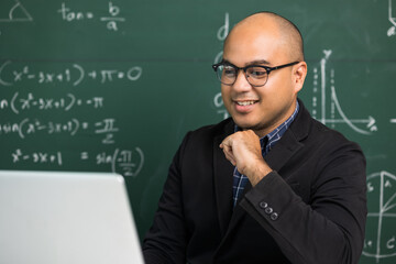 Indian young teacher man sitting teaching online video conference live stream by laptop. Asian teacher teaching mathematics class webinar online for students learning.