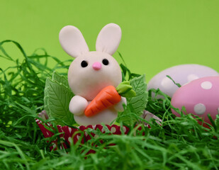 Cute easter baby bunny toy on a green background stock images. Easter decoration with cute little rabbit and polka dot eggs images. Easter animal figurine still life stock photo