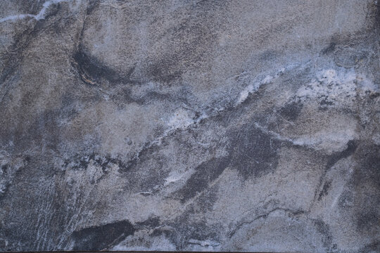 White marble pattern with curly grey and gold veins. Abstract texture and background.