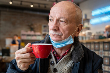 senior man enjoying cup of coffee in cafe