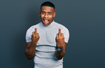 Young black man wearing casual t shirt showing middle finger doing fuck you bad expression,...