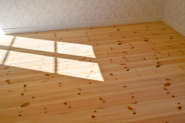 sunshine through window on wooden floor making shadows