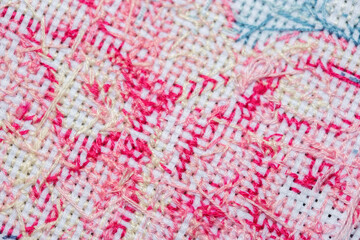 Close-up of the wrong side of a cross-stitched canvas with a pattern