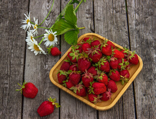 Fresh organic strawberries on a wooden plate. .Red ripe berries, fresh juicy strawberries. Healthy or diet food concept.