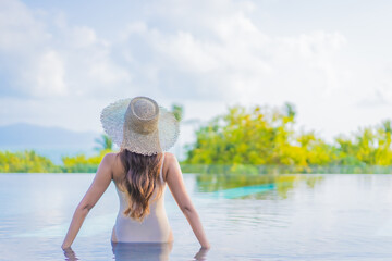 Portrait beautiful young asian woman enjoy around outdoor swimming pool with sea view