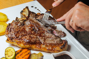 Costata di manzo cotta sulla brace con contorno di patate e verdure grigliate