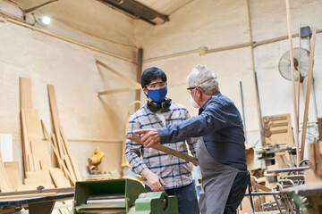 Handwerker Senior und Lehrling in Ausbildung in Werkstatt
