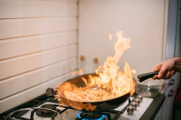 Frying pan with vegetables and meat close-up.