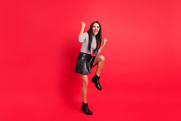 Full length body size view of attractive overjoyed lucky cheerful long-haired girl rejoicing having fun isolated over bright red color background