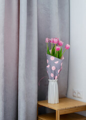 Bouquet of pink tulips near the window. Tulips in the interior.