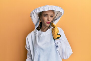 Beautiful blonde caucasian woman wearing protective beekeeper uniform touching mouth with hand with painful expression because of toothache or dental illness on teeth. dentist