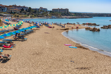 Beautiful sandy Cyprus beach. Umbrellas and sunbeds on Coral beach in Paphos, Cyprus. 