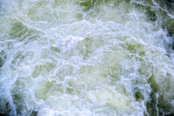 Fototapeta na wymiar Aerial view of river waterfall with clear turquoise water falling down with thick white foam.