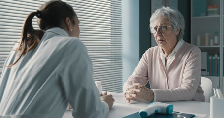 Naklejka premium Caring doctor assisting a senior patient