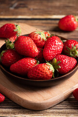 Fresh strawberries in a plate on wooden table