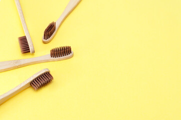 Bamboo toothbrush on a yellow background. Dental care. Top view, space for text.  