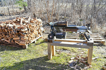 electric wood splitter standing infront of firewood