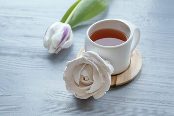 Morning concept. Cup of tea, marshmallow, tulip. White cup with tea, pink tulips and marshmallows.