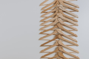 Many wooden hangers for clothes pattern on white background. Flat lay, top view minimalistic fashion, merchandise, shopping, store, sale concept.