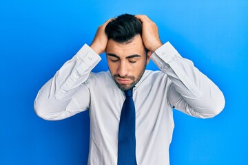 Young hispanic man wearing business clothes suffering from headache desperate and stressed because pain and migraine. hands on head.