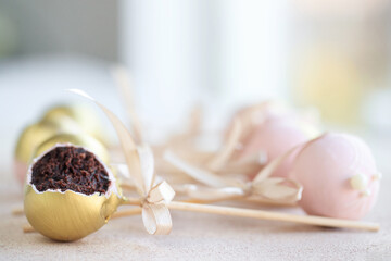 Fototapeta na wymiar The pastry chef decorates cake pops with satin ribbons.Various cake pops decorated with white and dark chocolate on a brown background. High quality photo.