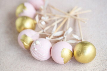 The pastry chef decorates cake pops with satin ribbons.Various cake pops decorated with white and dark chocolate on a brown background. High quality photo.