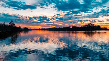 Beautiful sunset with reflections and dramatic clouds near Plattling, Isar, Bavaria, Germany