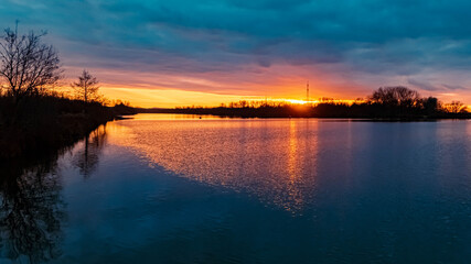 Beautiful sunset with reflections and dramatic clouds near Plattling, Isar, Bavaria, Germany