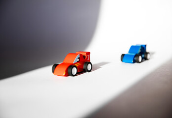 Red and blue wooden toy cars with numbers 1 and 2.