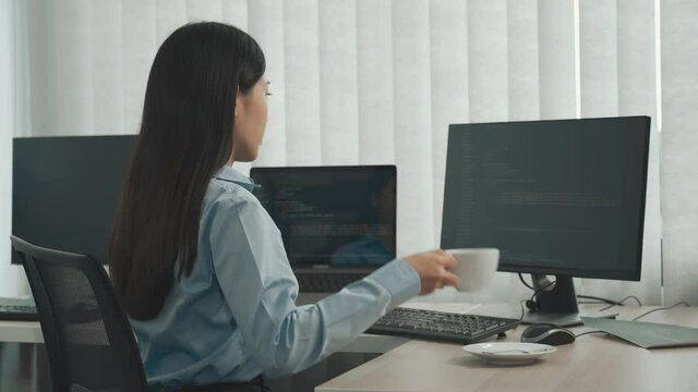 Asian software developers are sitting and working in the morning.