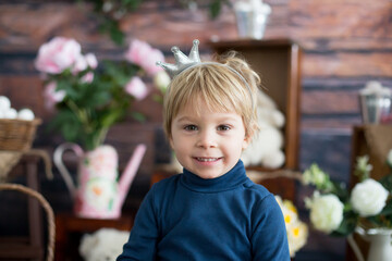 Beaufitlu toddler blond boy, wearing little crown, pretending to be prince